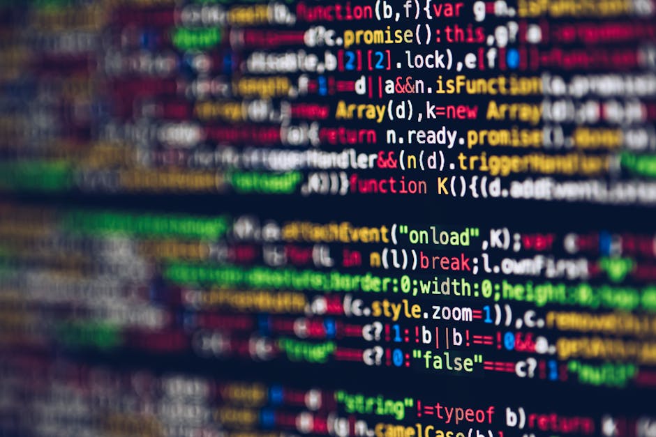 A close-up photograph of a computer screen displaying lines of colorful programming code in various shades of red, blue, green, yellow, and white on a dark background. The code includes syntax highlig